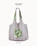 Saigon Concepts own beach tote bag in natural linen with green palm leaf pattern on a white background.