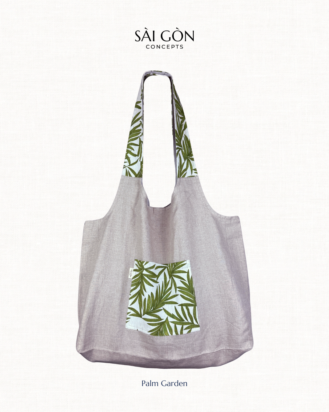 Saigon Concepts own beach tote bag in natural linen with green palm leaf pattern on a white background.