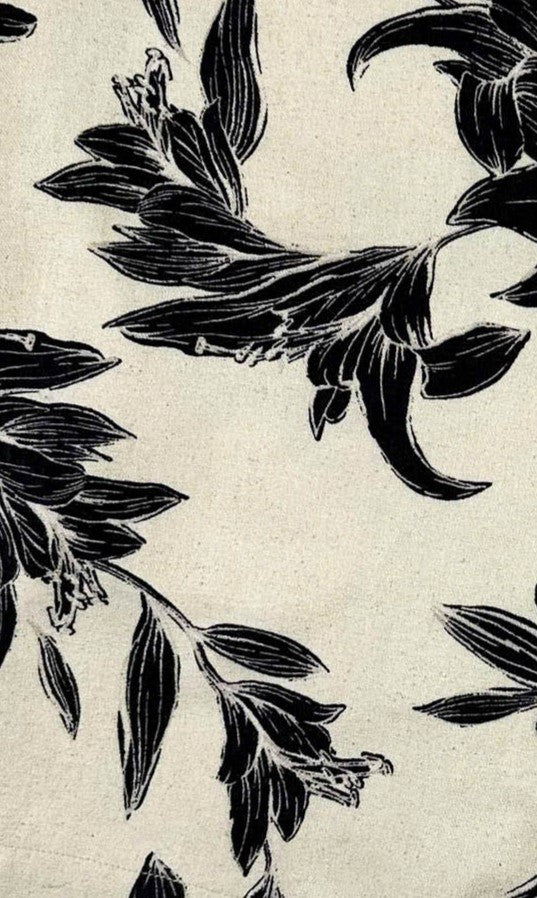 Black leaf floral pattern on a beige linen background