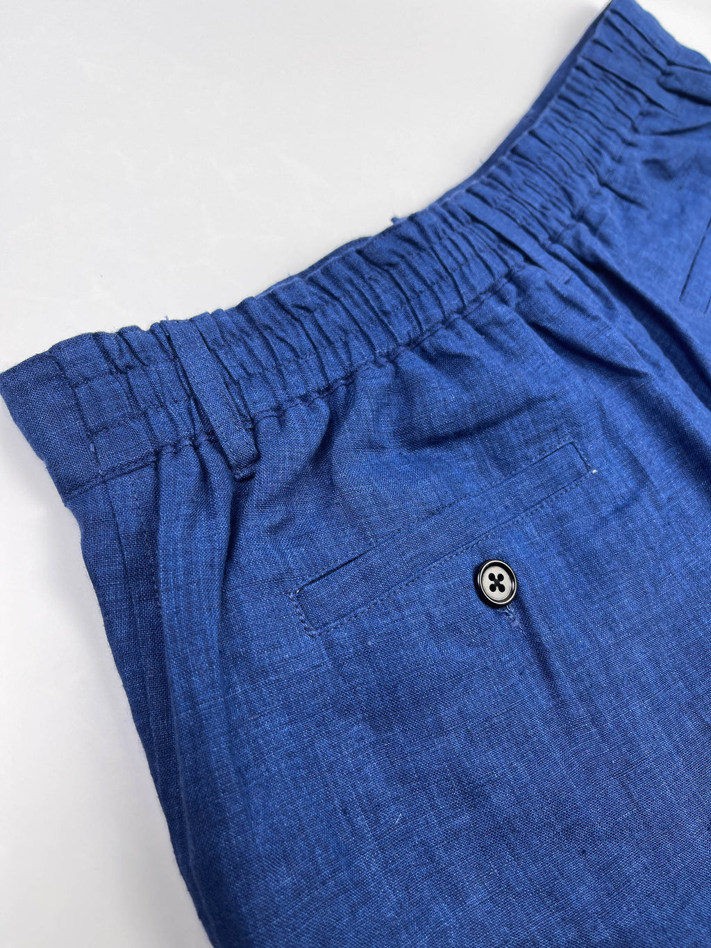 Saigon Concepts Mid Blue Riviera Linen Shorts - back elasticated waistband and back pocket with button closure view