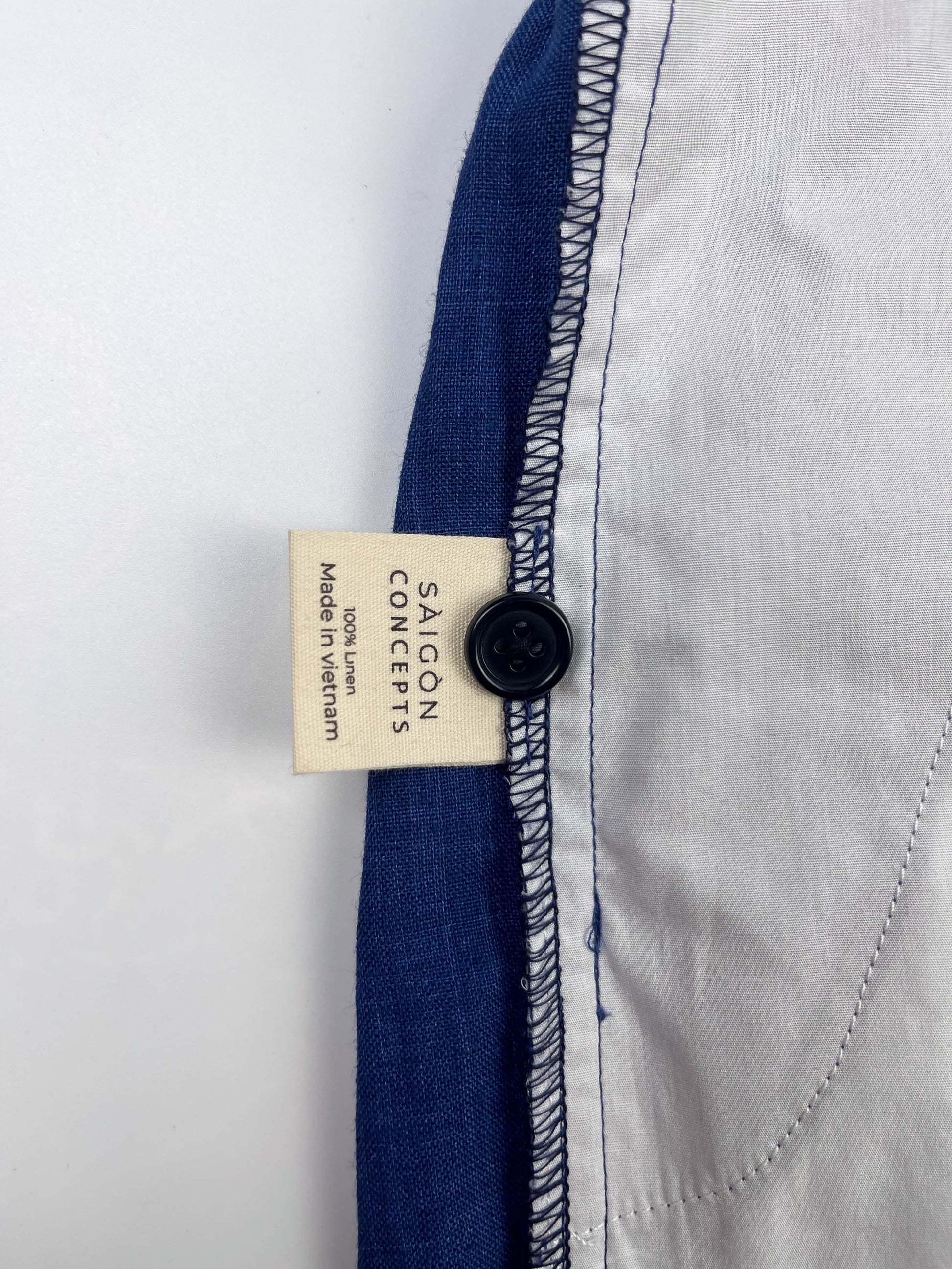 Saigon Concepts Mid Blue Riviera Linen Shorts - inside care label and spare button detail view