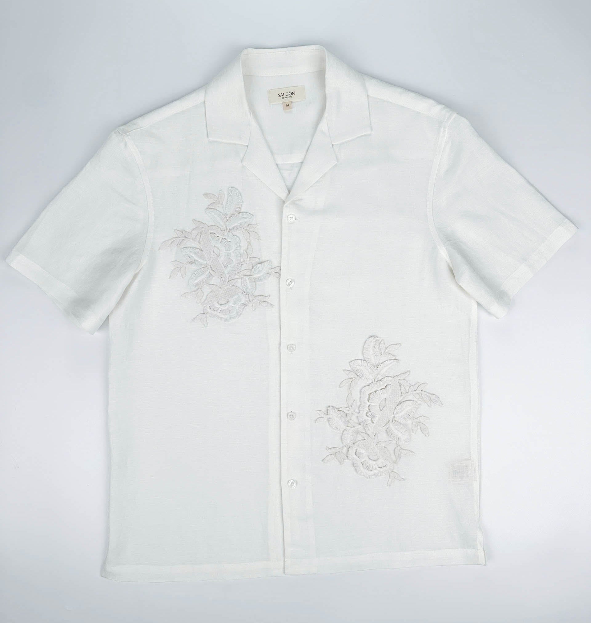 Saigon Concepts White linen hawaiian style shirt with floral lace application on a light gray background