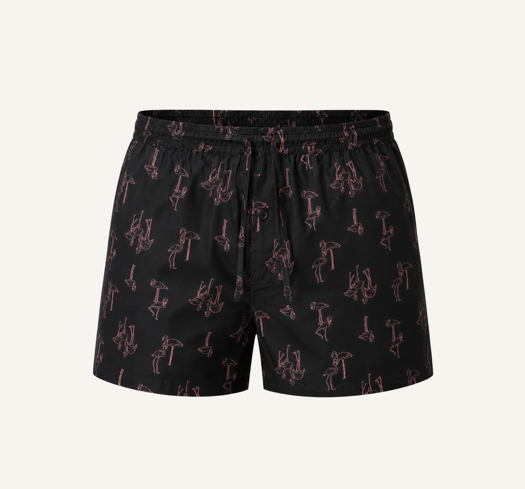 Ghost mannequin front view of dark shorts with a pink flamingo print