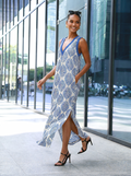Woman wearing a light blue patterned halter maxi dress, walking outdoors