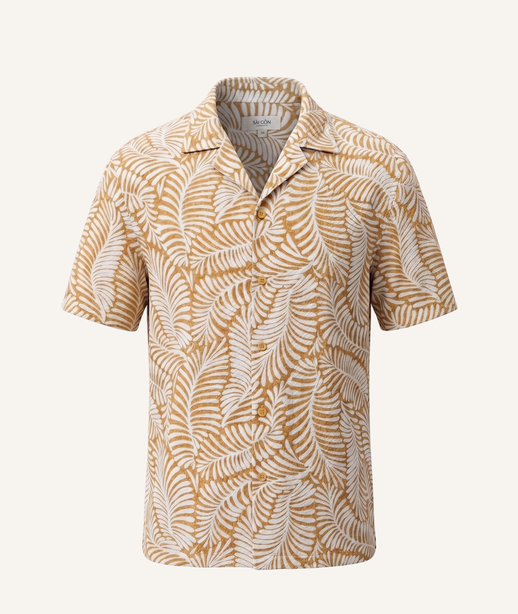A short-sleeve camp collar button-up shirt featuring an all-over tropical palm leaf pattern in mustard yellow and off-white, displayed on a clean, light cream background.