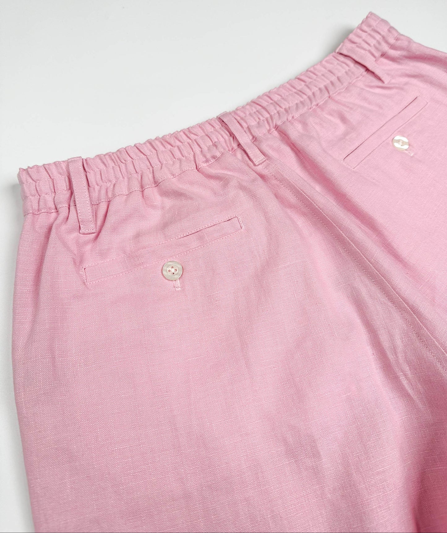 Saigon Concepts blush pink linen shorts - elasticated back and two back pockets with button closure detail view