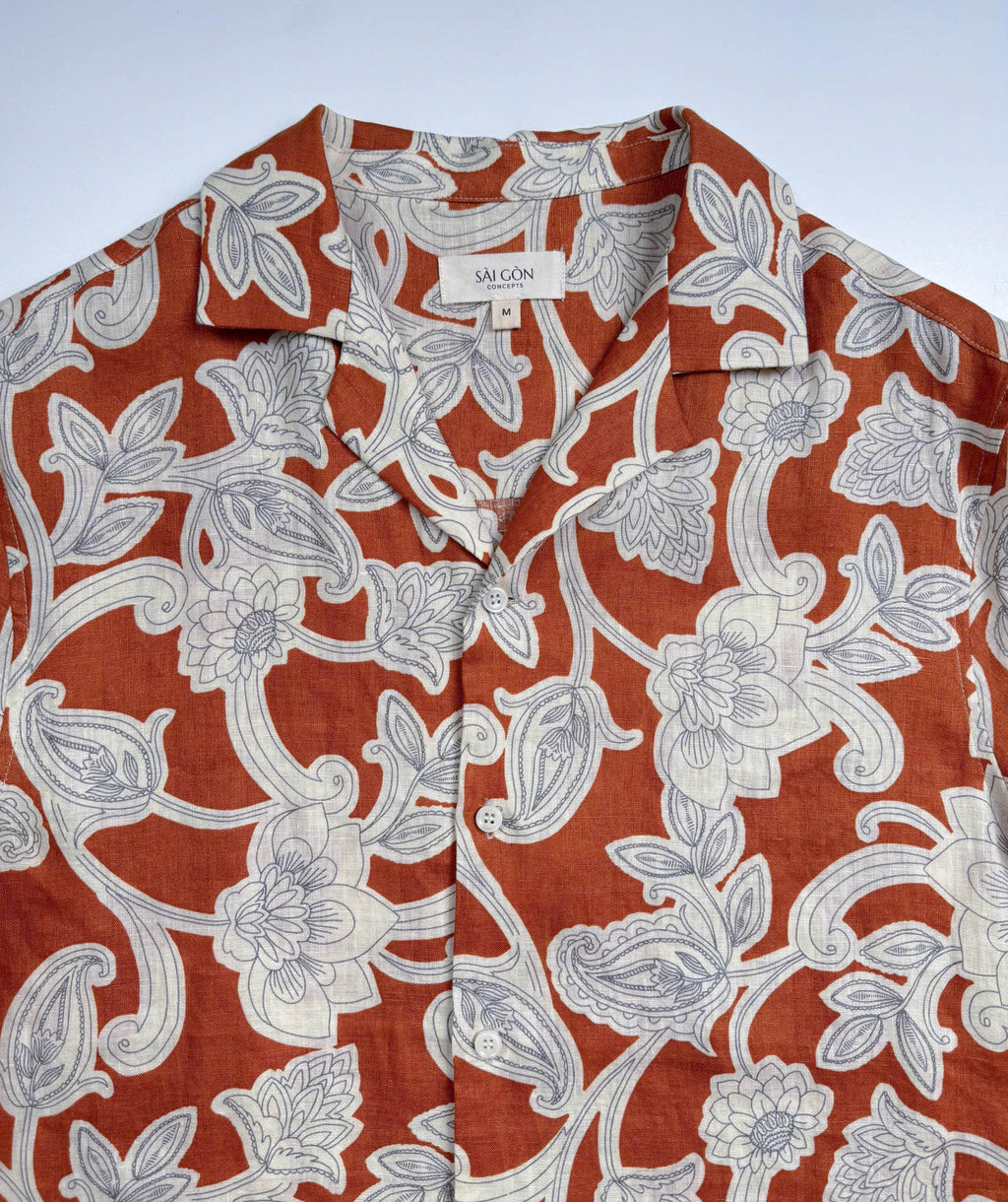 Saigon Concepts Annam Vine Hawaiian Shirt with white edged floral print on rust-orange linen fabric - lay flat front neck view