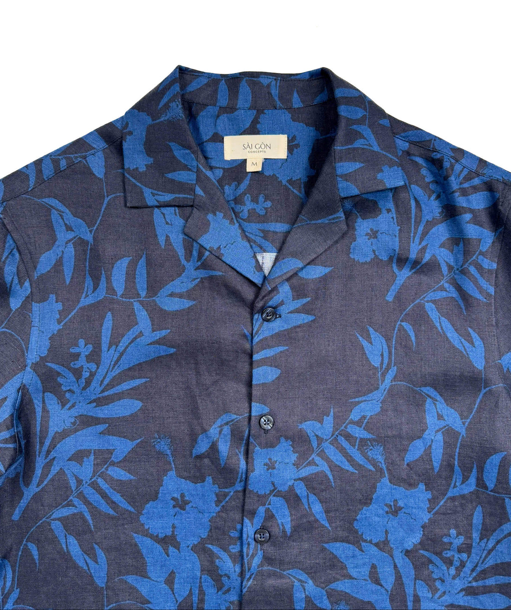 Saigon Concepts Hawaiian Shirt with blue leaf patterned print on a dark navy linen - lay flat front neck view