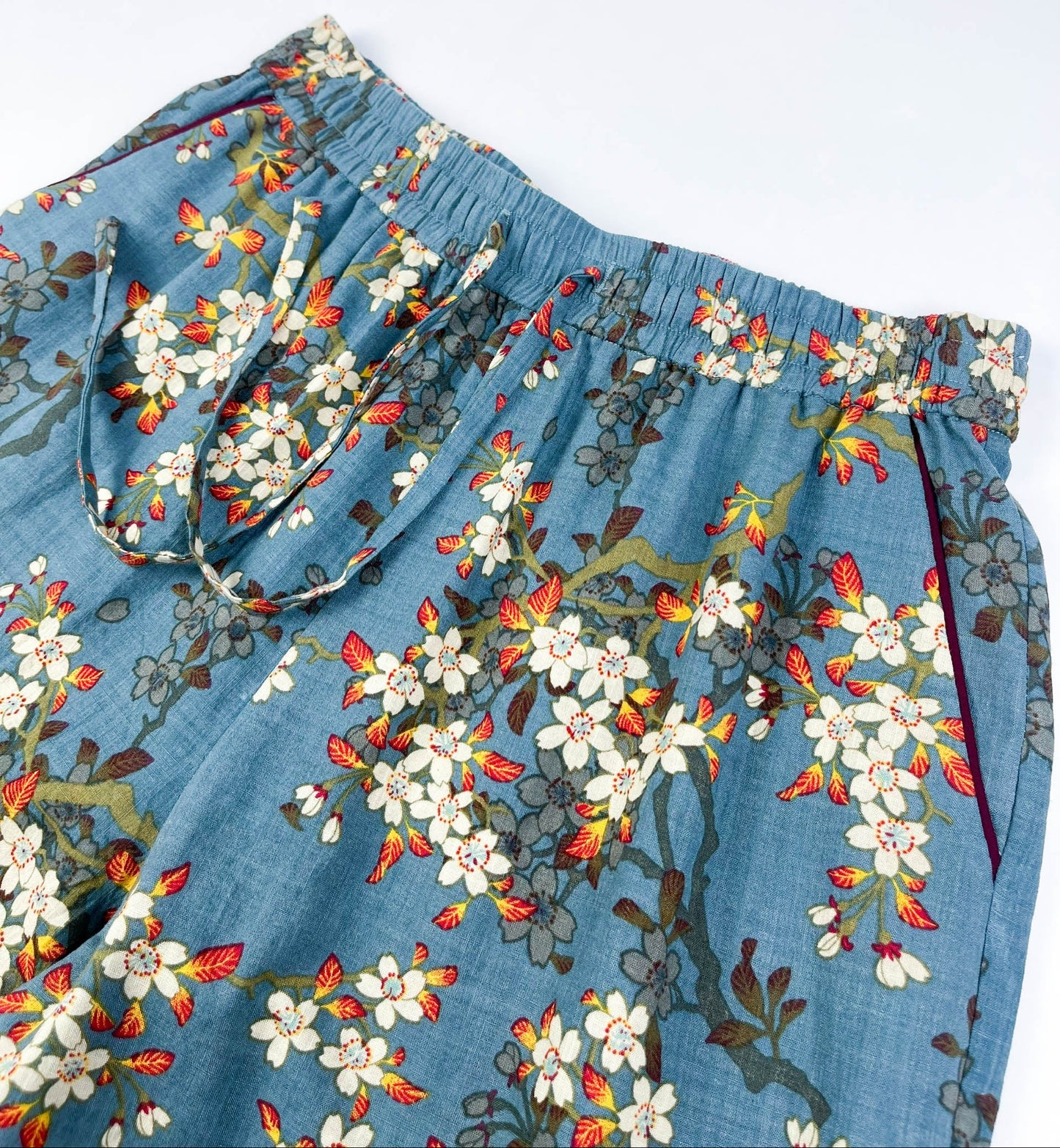 front waistband view of Long Pyjama pants in Teal Blue cotton-linen fabric with delicate white blossom print with contrast piping - Saigon Concepts