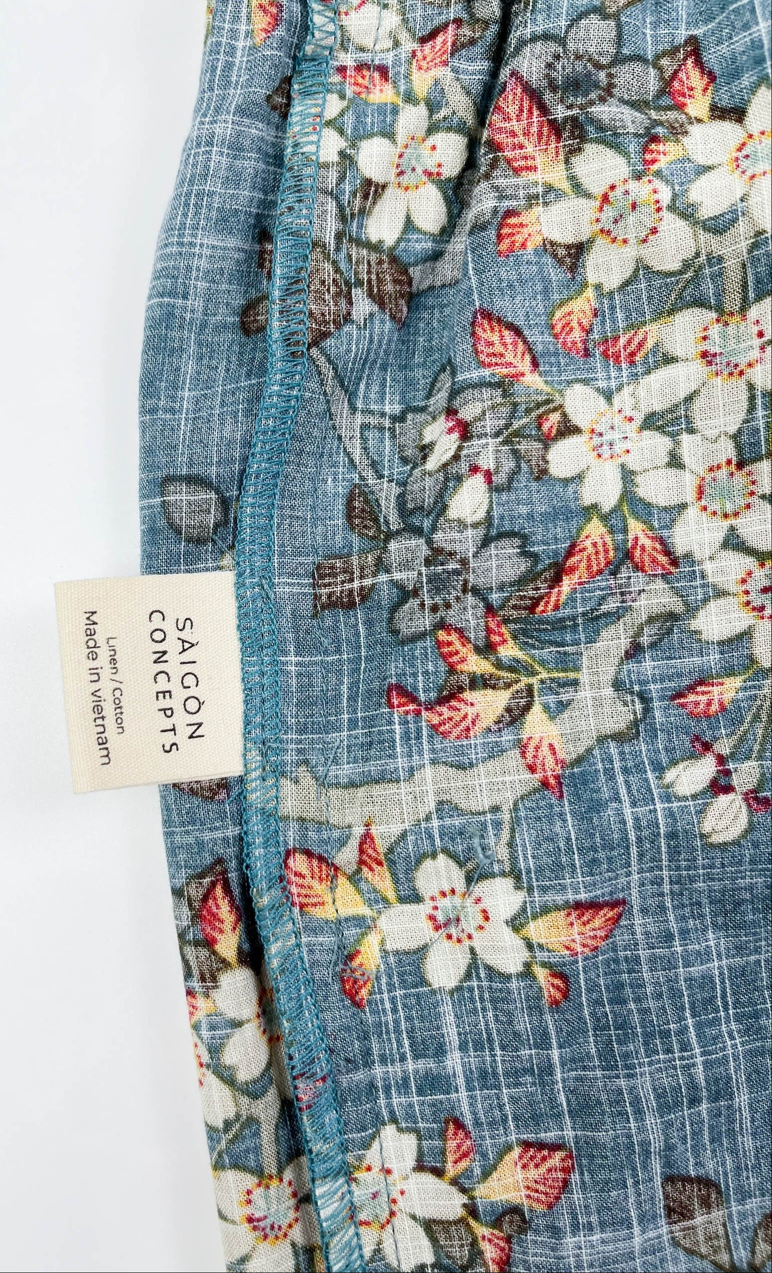 Female Lounge Shorts in teal blue with white blossom floral print. Inside care label detail view - Saigon Concepts
