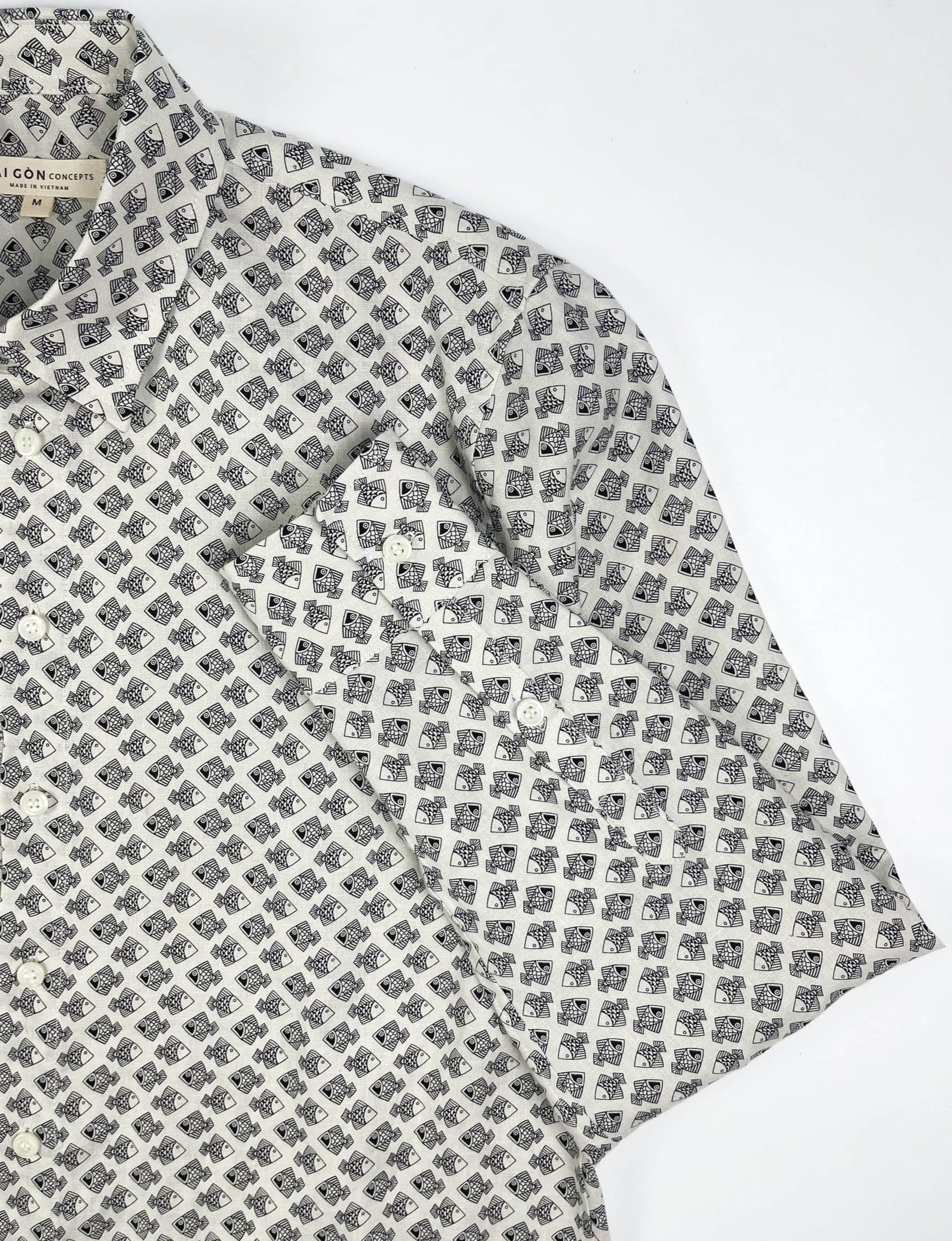 Tiny Black Fish linen long sleeve button-up shirt lay flat sleeve detail view, small fish print on natural white base