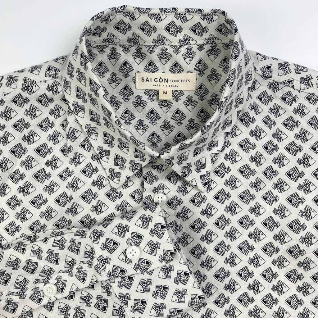 Tiny Black Fish linen long sleeve button-up shirt lay flat collar detail view, small fish print on natural white base