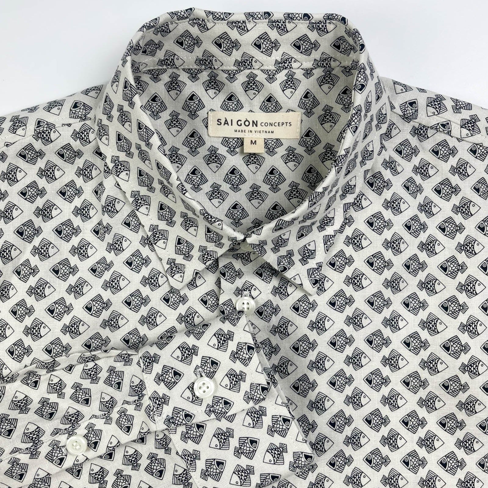 Tiny Black Fish linen long sleeve button-up shirt lay flat collar detail view, small fish print on natural white base