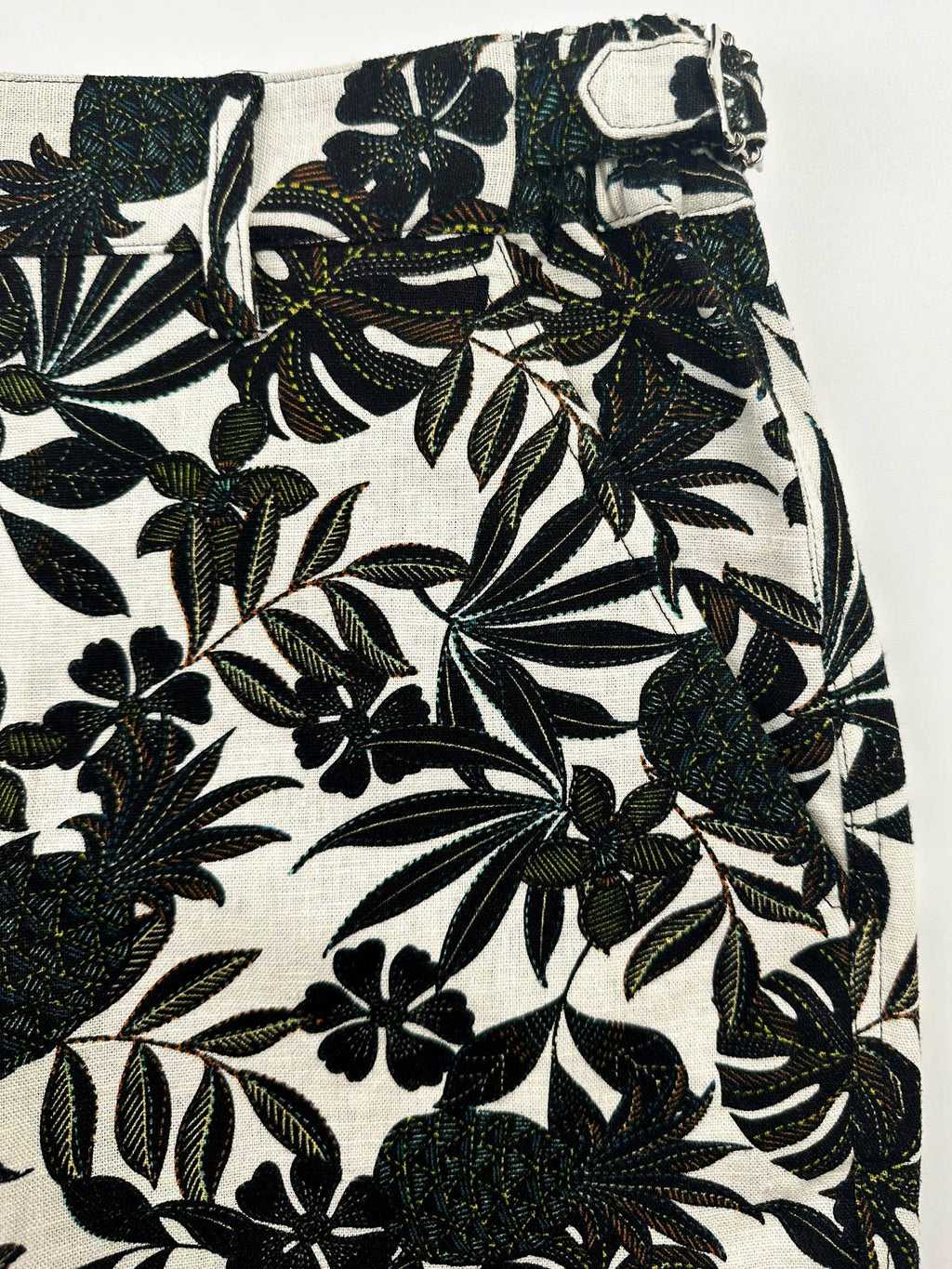 Pocket detail - Black tropical floral patterned linen shorts on a natural white background