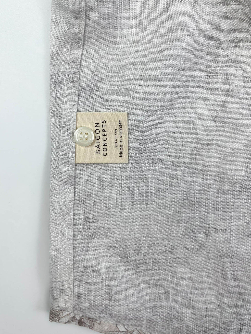 Tropicana Parrot long sleeve button-up shirt lay flat care label detail view, parrot and foliage print on natural white linen