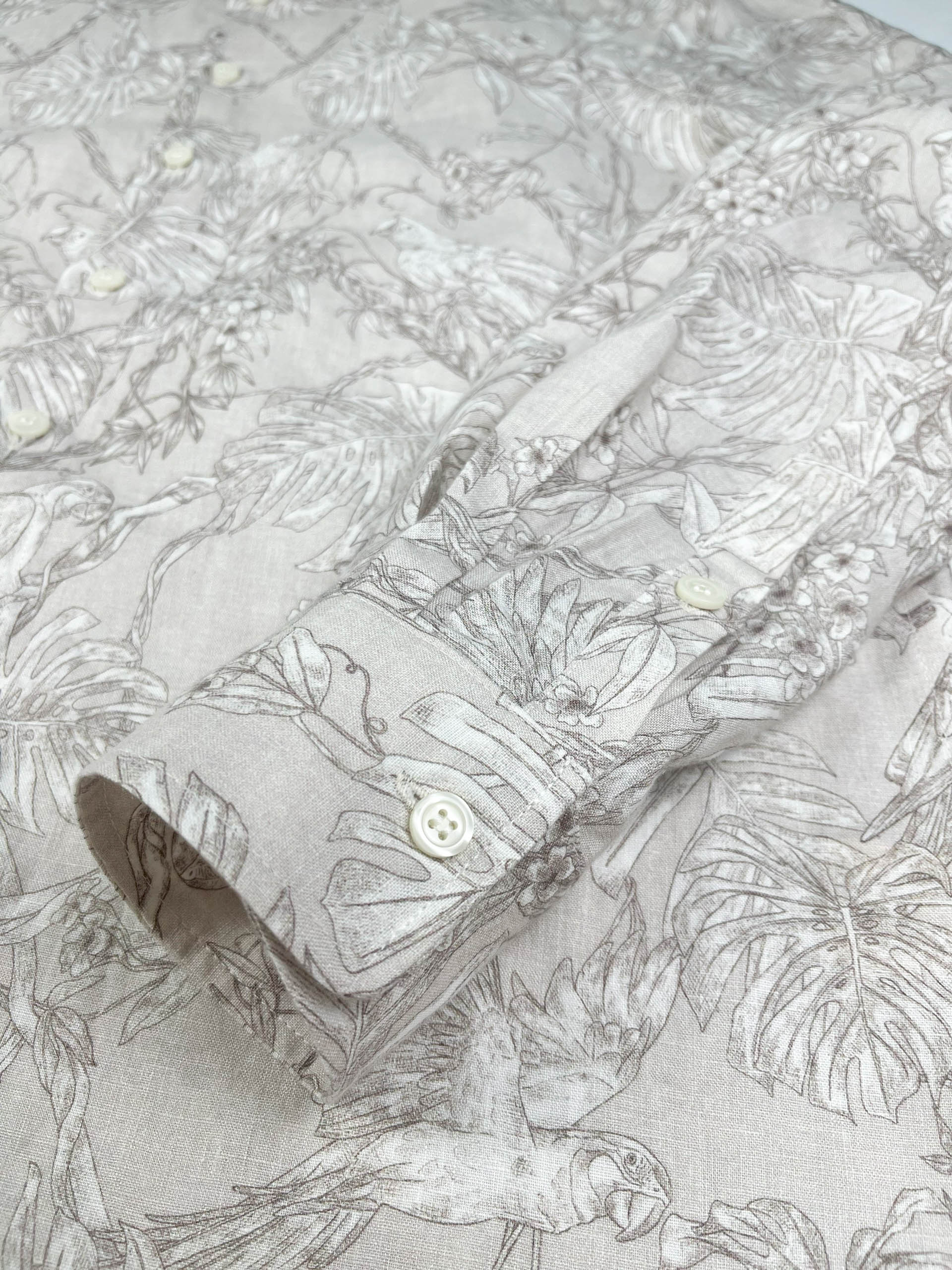 Tropicana Parrot long sleeve button-up shirt lay flat cuff detail view, parrot and foliage print on natural white linen