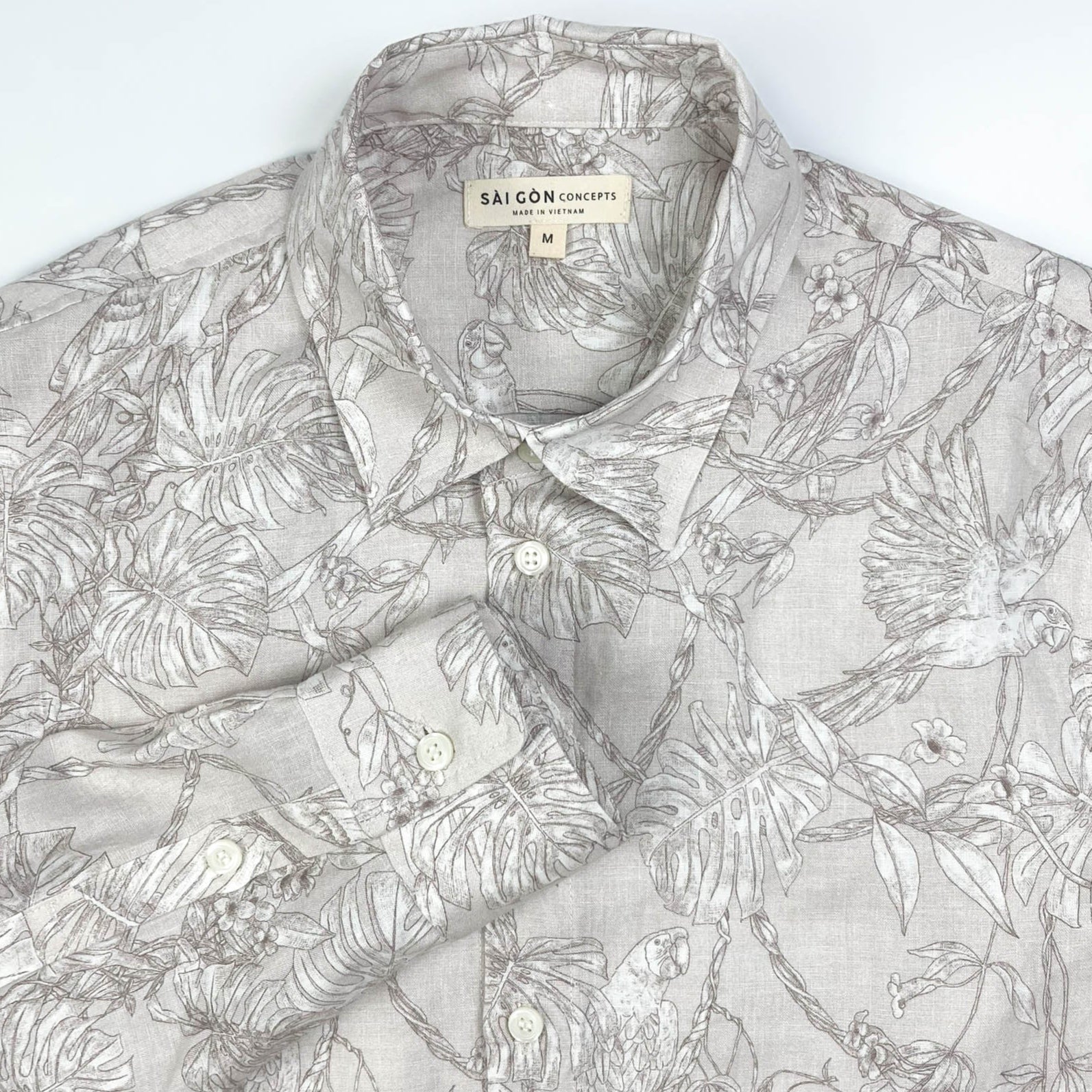 Tropicana Parrot long sleeve button-up shirt lay flat collar detail view, parrot and foliage print on natural white linen