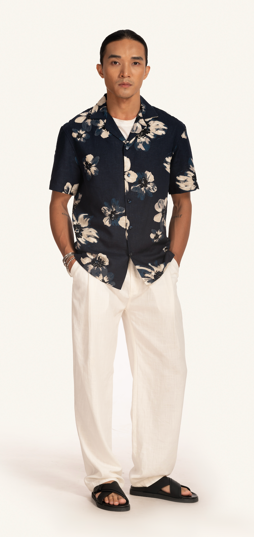 Man wearing Saigon Concepts dark floral Hawaiian shirt and white linen pants